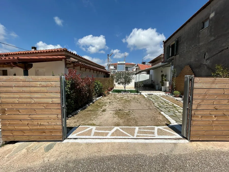 Η ξύλινη αυλόπορτα και ο χώρος στάθμευσης